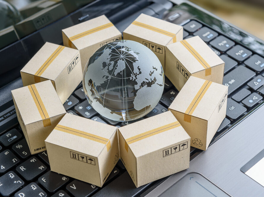 A globe on top of a laptop keyboard surrounded by boxes