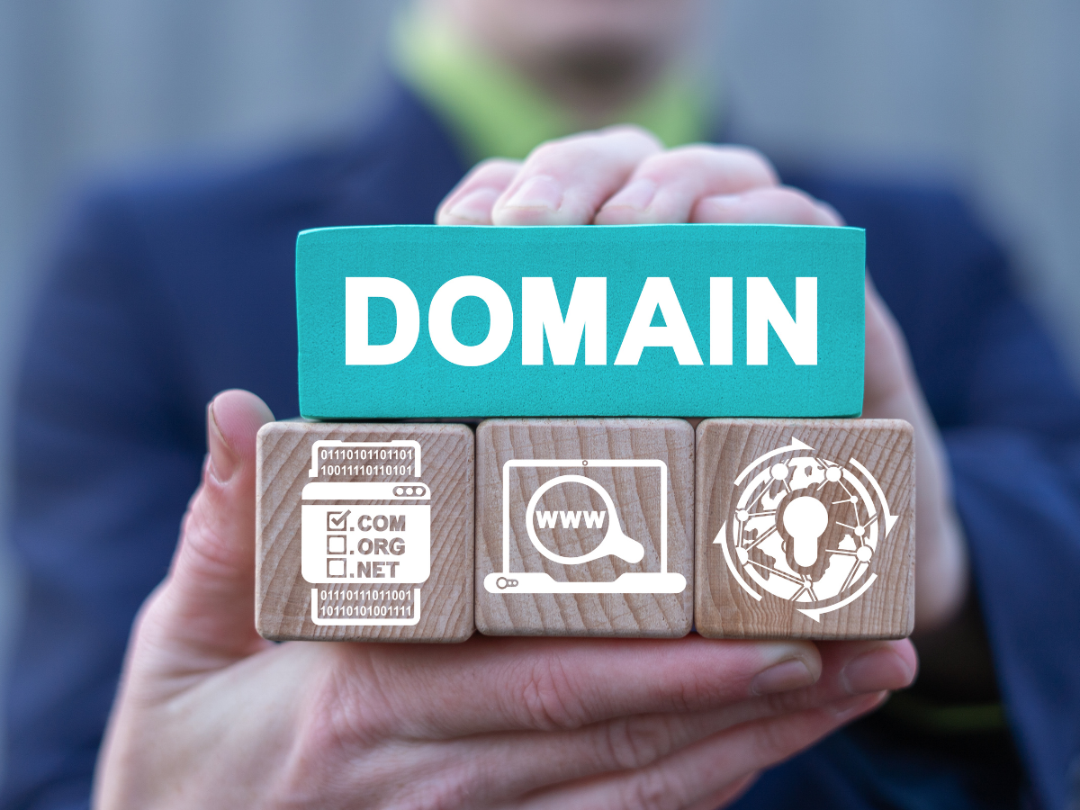 A man holding blocks with text that says domain and icons depicting the domain industry